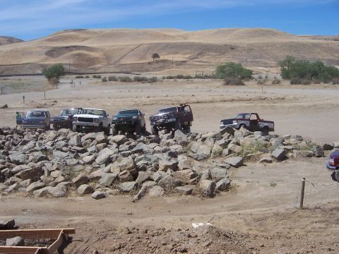 1991 Ford Bronco - Multiple off-road vehicles navigate a challenging rocky terrain under a clear blue sky.