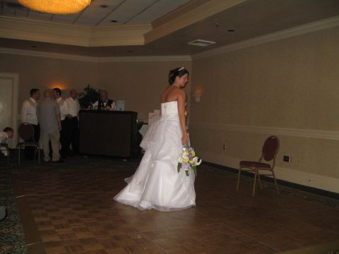 1988 Ford Bronco - A bride stands on a wooden dance floor, holding a bouquet of flowers.