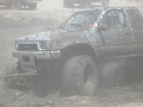 1985 Ford Bronco - This Toyota truck is covered in mud while navigating a challenging off-road course.