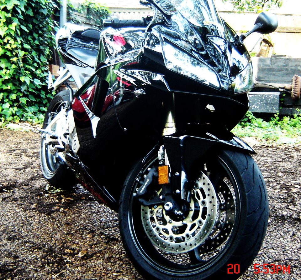 Front three-quarter view of a black Honda sportbike on a gravel driveway