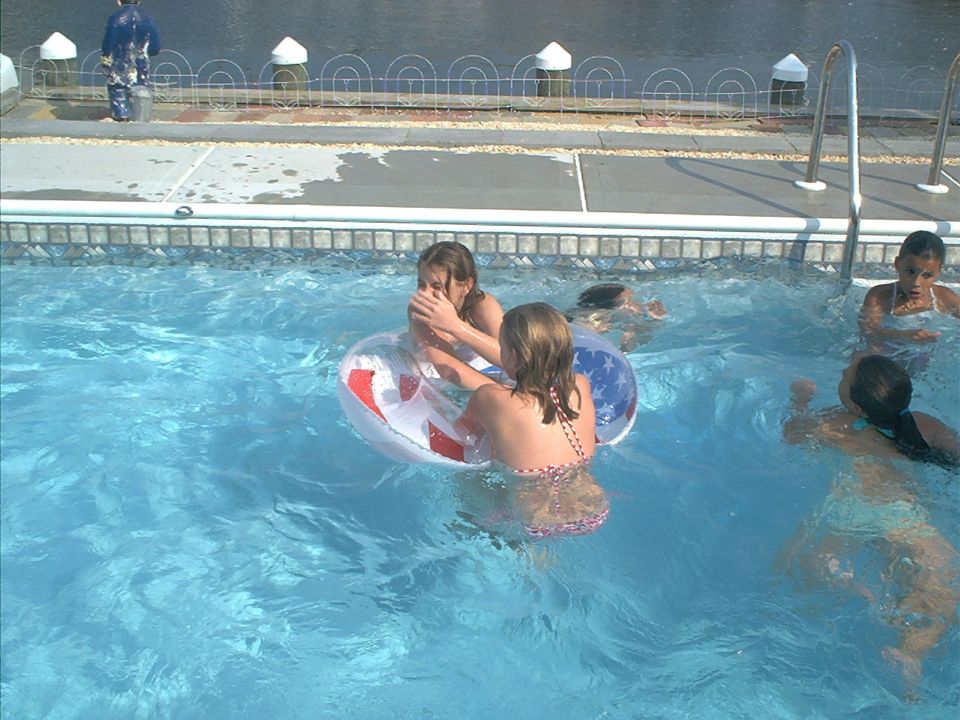 Children play in a swimming pool with inflatable rings