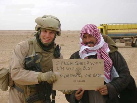 1990 Ford Bronco - Two men, one in military uniform and the other in traditional Middle Eastern attire, pose with a cardboard sign in a desert landscape.