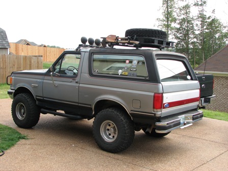 1991 Ford Bronco - This 1991 Ford Bronco is equipped with a roof rack, spare tire, and auxiliary lights, suggesting it's ready for adventure.