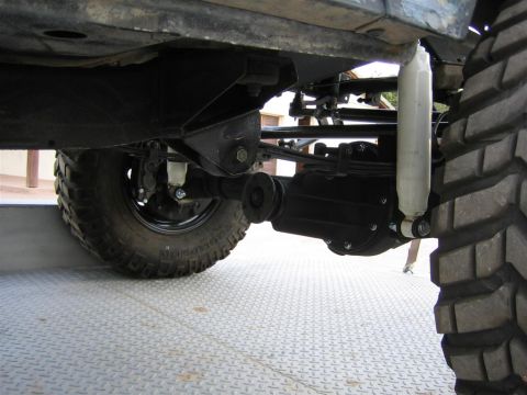 1987 Suzuki Samurai - Undercarriage view of a vehicle's suspension system, showing the rear axle and shock absorber.