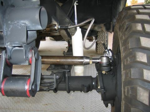 1987 Suzuki Samurai - Detailed view of the steering and suspension system on an off-road vehicle, showing the linkage and shock absorber.