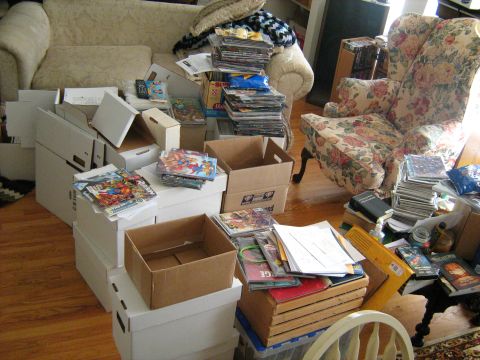 1988 Mercury Grand Marquis - A living room floor covered in stacks of comic books, white long boxes and cardboard shipping boxes being sorted, with a floral wingback ar…