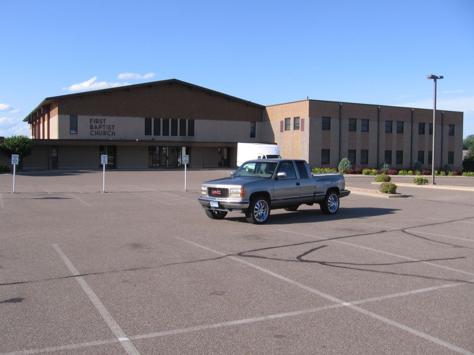 Silver GMC pickup truck parked in a church parking lot