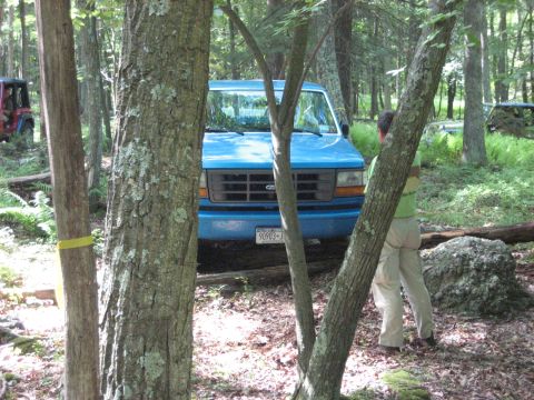 1991 Ford Bronco - Blue Ford Econoline van parked in a wooded area with a red Jeep in the background.