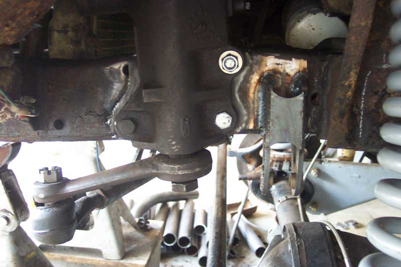 Close-up of a steering box and tie rod end assembly on a vehicle frame