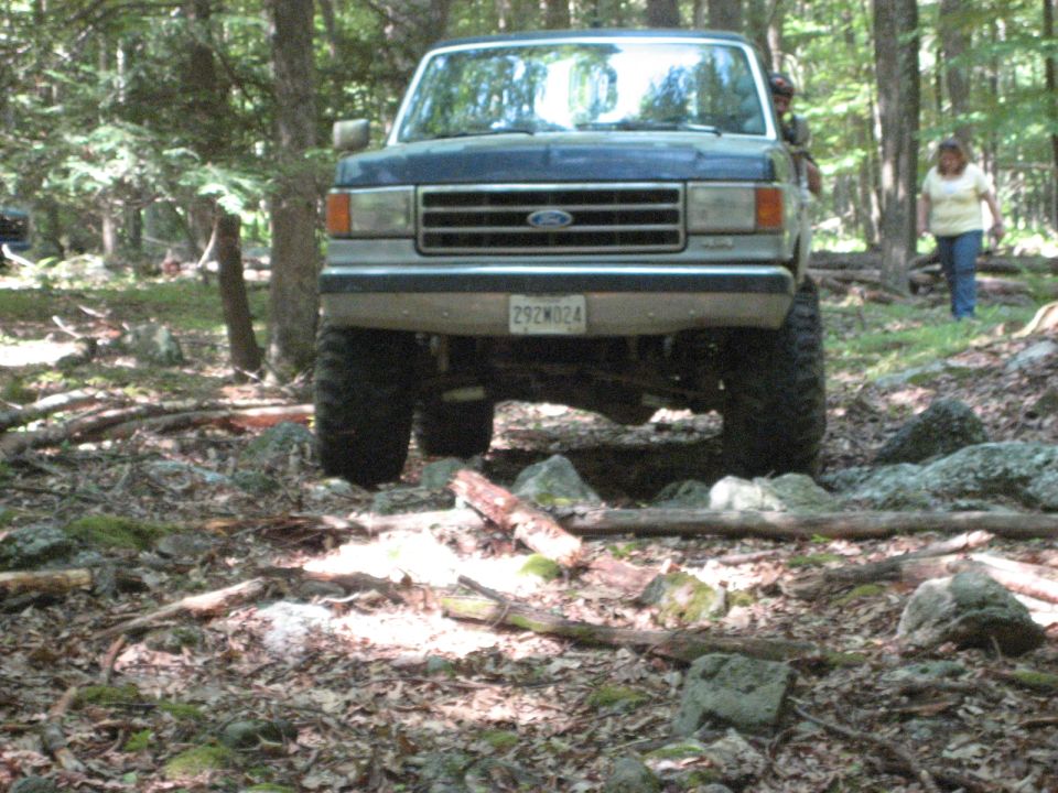 1991 Ford Bronco front view, blue, off-roading on rocky terrain