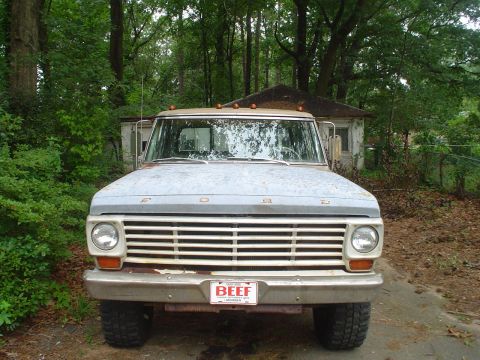 1967 Ford F-250 - A weathered 1967 Ford F-250 truck sits in a driveway, its front grille showing signs of age.