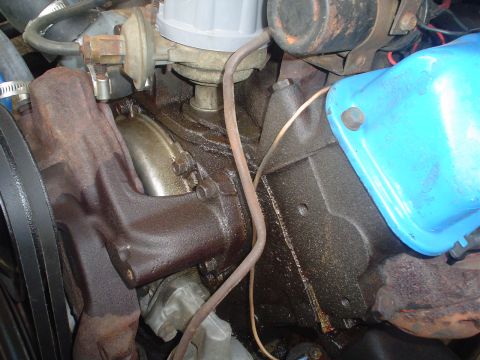 1967 Ford F-250 - Engine components are visible in this close-up shot, showing a distributor and exhaust manifold.