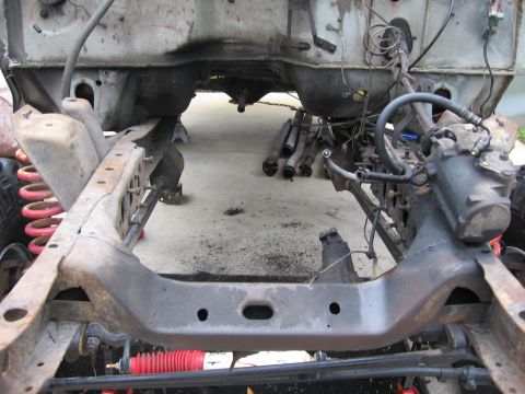 1974 Ford F-100 - The chassis of a truck, likely from the 1970s, is shown with its engine removed and suspension components visible.