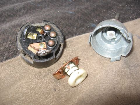 1974 Ford F-100 - Disassembled ignition switch components are laid out on a textured surface.