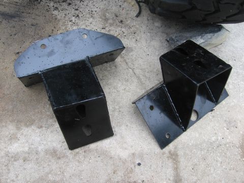1974 Ford F-100 - Two black metal brackets are shown on a concrete surface, with a tire visible in the upper right corner.