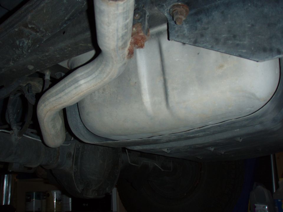 Undercarriage view of a vehicle's exhaust pipe and fuel tank