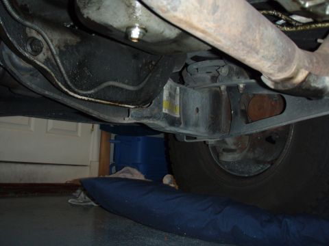 1996 Ford Bronco - A view from underneath a vehicle, focusing on the suspension and exhaust system components.