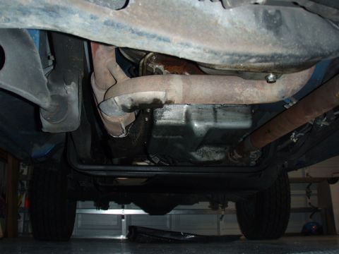 1996 Ford Bronco - The underside of a 1996 Ford Bronco reveals its exhaust system, oil pan, and driveshaft components.