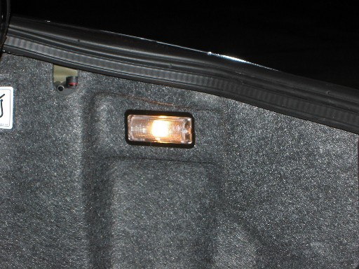 Illuminated trunk courtesy light on gray carpeted trunk lid panel