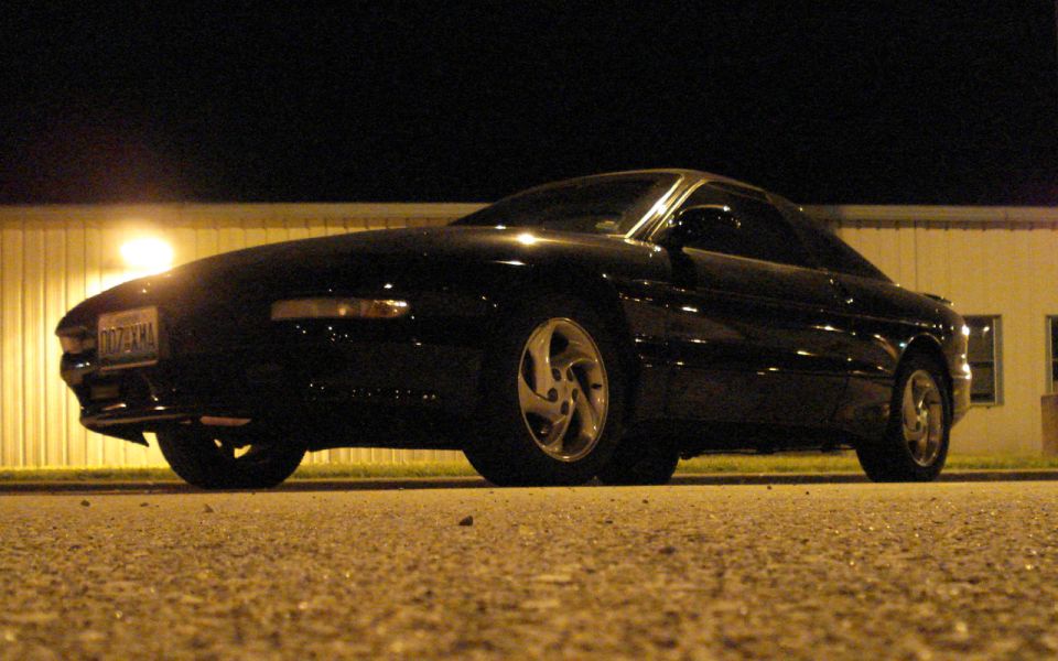 Black Ford Probe photographed from ground level at night under a streetlight