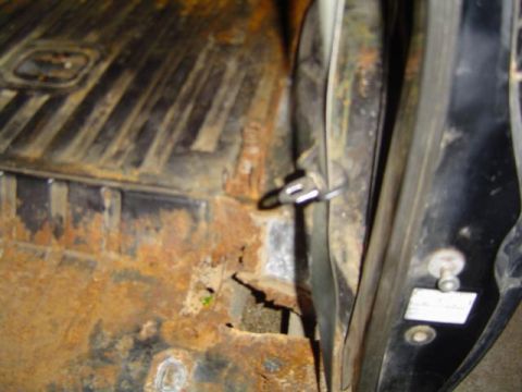 1979 Ford Bronco - The interior shows significant rust damage on the floor and door jamb, indicating poor condition.