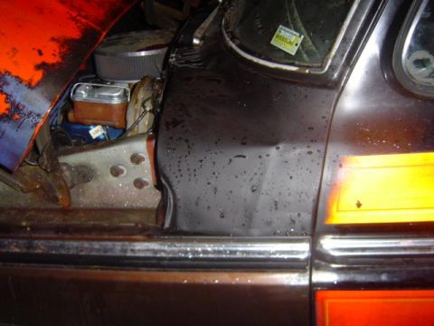 1979 Ford Bronco - Close-up of the engine bay and fender of a 1979 Ford Bronco, orange and black paintwork.