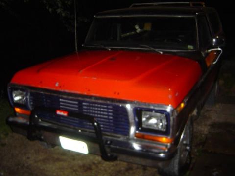 1979 Ford Bronco - Front view of a 1979 Ford Bronco, a red hood and blue grille.