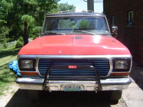 1979 Ford Bronco - This red Ford Bronco features a distinctive blue grille and a protective grille guard on its front end.