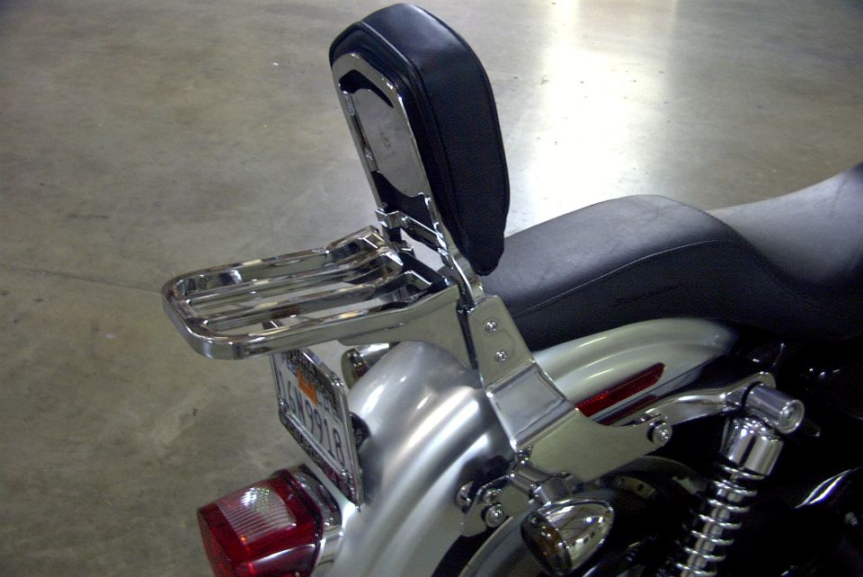 Chrome sissy bar backrest and luggage rack on a silver cruiser motorcycle fender