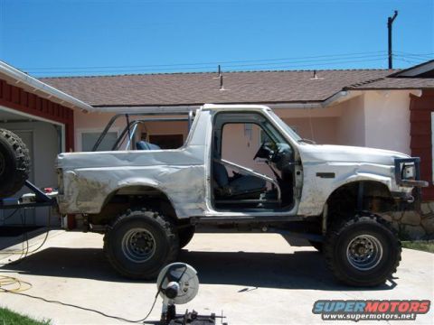 1996 Ford Bronco - This modified Ford Bronco, likely from the early to mid-1990s, is undergoing modifications with a visible roll cage and off-road tires.