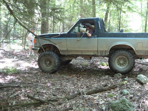 1991 Ford Bronco - This lifted Ford Bronco navigates a wooded trail, its off-road capabilities.