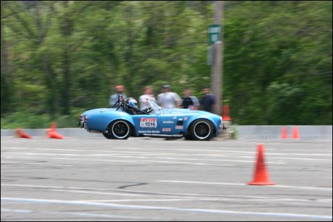 2001 Mercury Grand Marquis - A blue convertible race car navigates a course marked by orange cones, with spectators in the background.