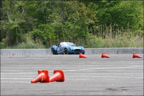 2001 Mercury Grand Marquis - A blue convertible sports car navigates an autocross course marked by orange cones.