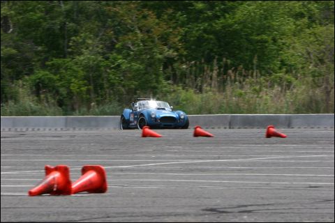 2001 Mercury Grand Marquis - A blue sports car navigates a course marked by orange cones on a paved track.