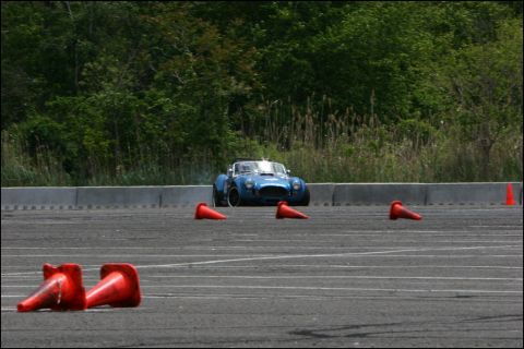 2001 Mercury Grand Marquis - A blue convertible sports car navigates a course marked by orange cones on a paved track.