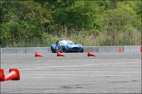 2001 Mercury Grand Marquis - A blue convertible sports car navigates a course marked by orange cones on a paved track.