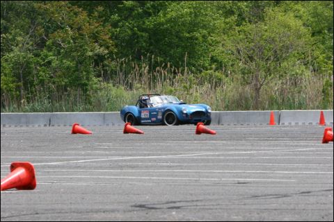 2001 Mercury Grand Marquis - A blue convertible sports car navigates a course marked by orange cones on a paved track.