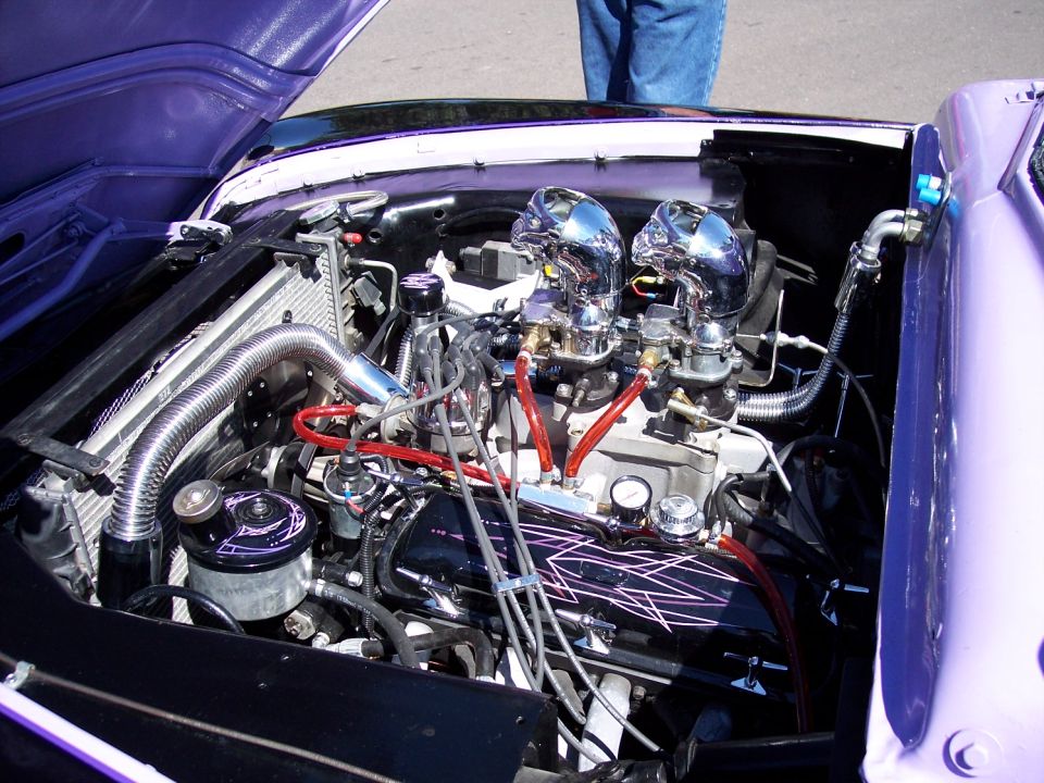Engine bay with dual chrome carburetors and purple accents