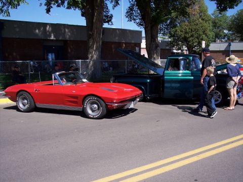 1972 Ford Ranchero - A red convertible sports car and a green pickup truck are parked on a street, possibly at a car show.