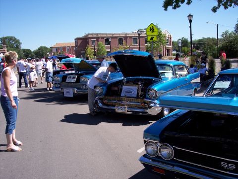 1972 Ford Ranchero - A line of classic cars, including a 1957 Chevrolet Bel Air, are displayed with their hoods open at a sunny outdoor event.