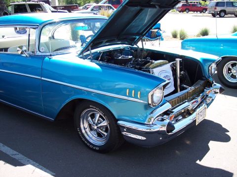 1972 Ford Ranchero - A classic blue Chevrolet with its hood up, parked outdoors next to another vehicle.