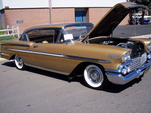 1972 Ford Ranchero - A gold 1958 coupe is parked with its hood open, revealing the engine bay and chrome accents.