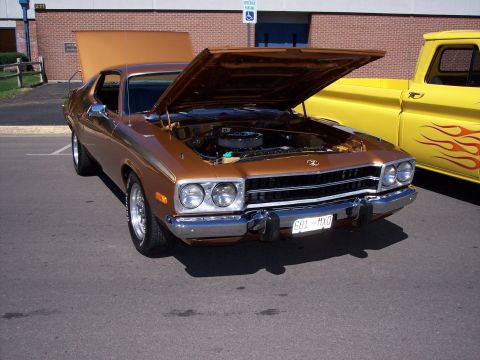 1972 Ford Ranchero - Front view of a brown 1972 Plymouth Road Runner, engine exposed, beside a yellow truck.