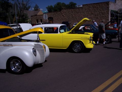 1972 Ford Ranchero - Two classic cars, a yellow 1955 Chevrolet and a white 1940s Ford, are displayed with hoods up.
