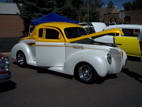1972 Ford Ranchero - A custom hot rod with its hood up sits on display next to another vehicle.