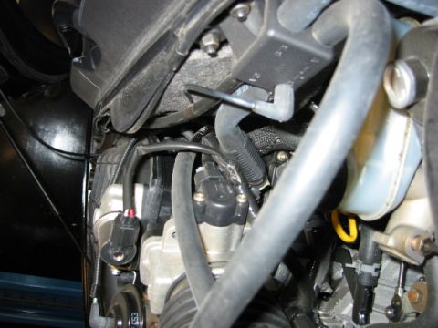 2002 Mercury Sable - Close-up view of engine bay components including hoses, wiring, and a fluid reservoir.