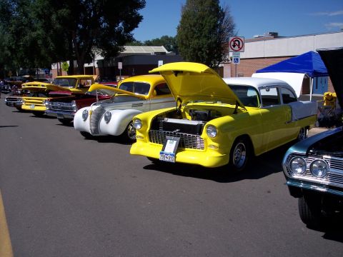 1972 Ford Ranchero - A row of vintage cars are displayed with their hoods up on a sunny day.