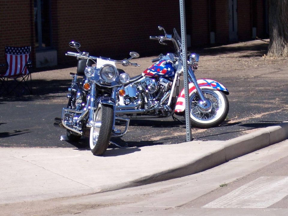 Two motorcycles painted with American flag motif parked on a sidewalk