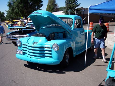 1972 Ford Ranchero - Turquoise Chevrolet pickup truck on display at an outdoor event, hood up for viewing.