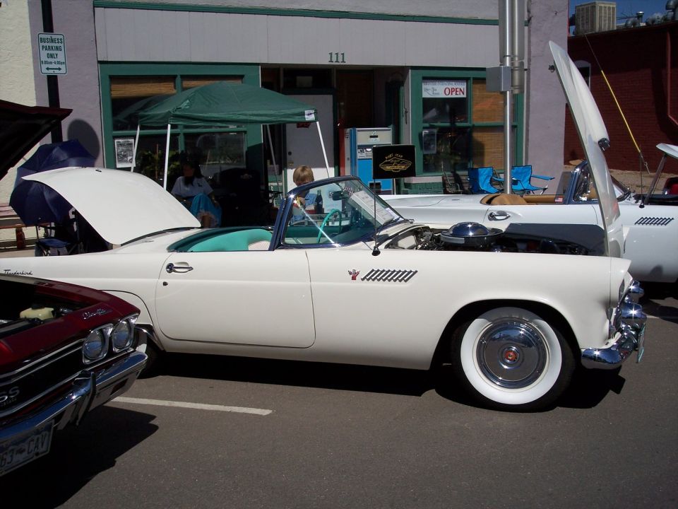 White 1957 Ford Thunderbird convertible, hood open, side view